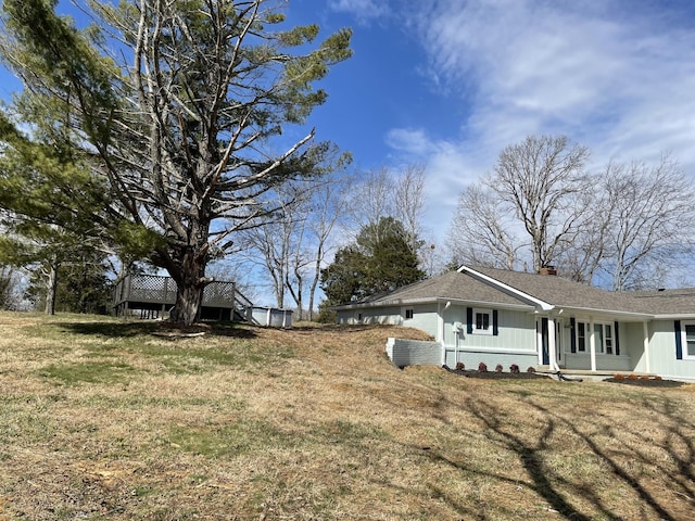 view of side of property with a chimney, a lawn, and brick siding