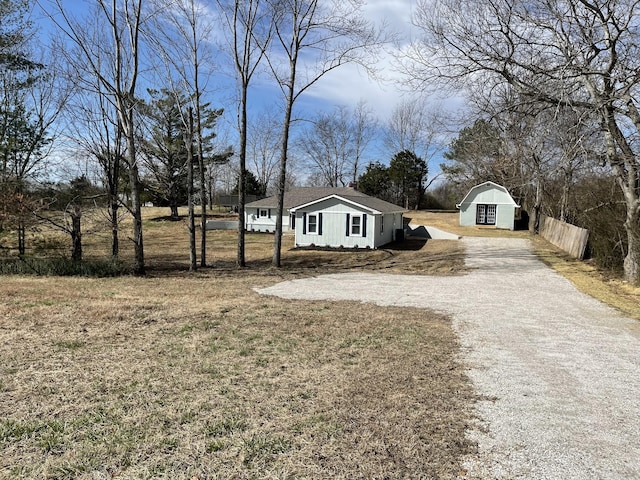 view of yard with gravel driveway and fence