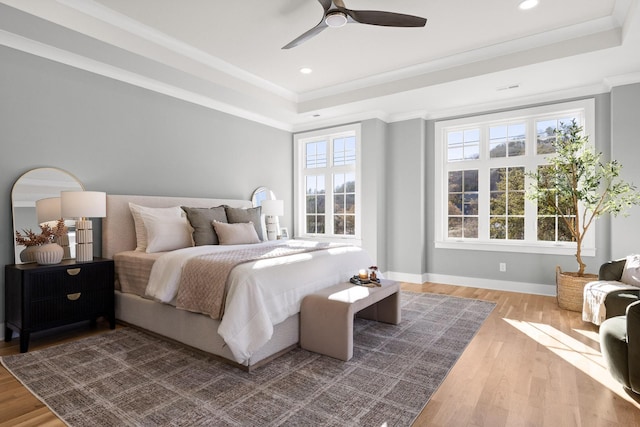 bedroom featuring baseboards, a raised ceiling, ornamental molding, wood finished floors, and recessed lighting