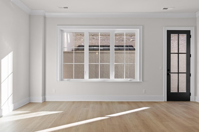 spare room featuring visible vents, baseboards, wood finished floors, and ornamental molding