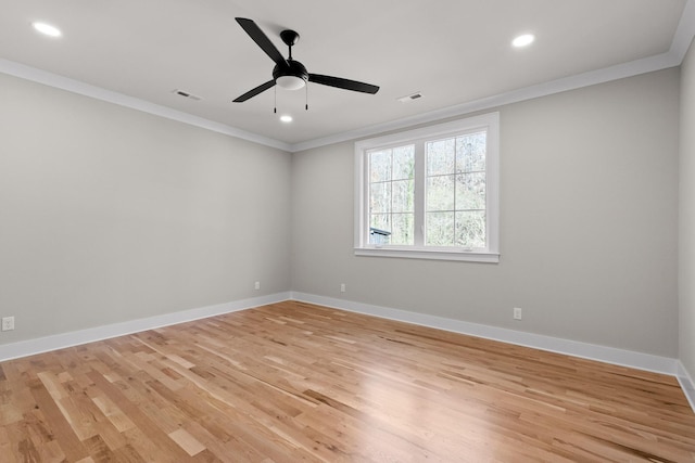 spare room with ornamental molding, visible vents, light wood finished floors, and baseboards