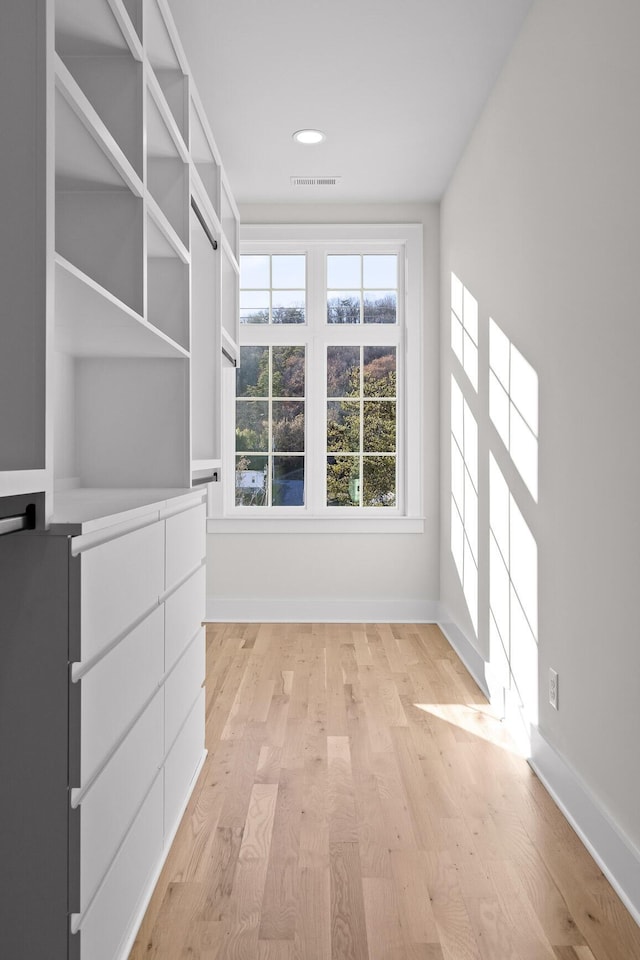 walk in closet featuring light wood-type flooring and visible vents