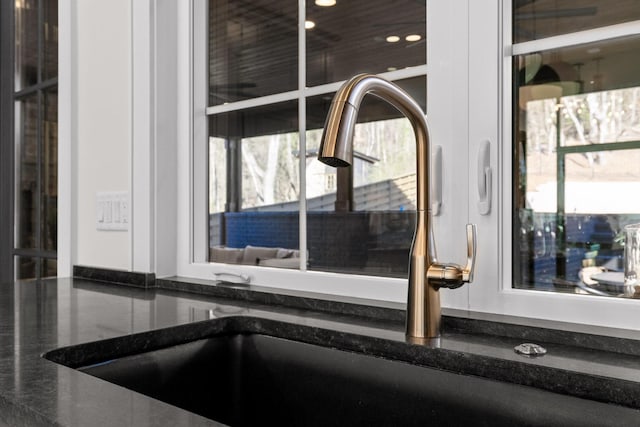 room details with dark stone countertops, a sink, and recessed lighting