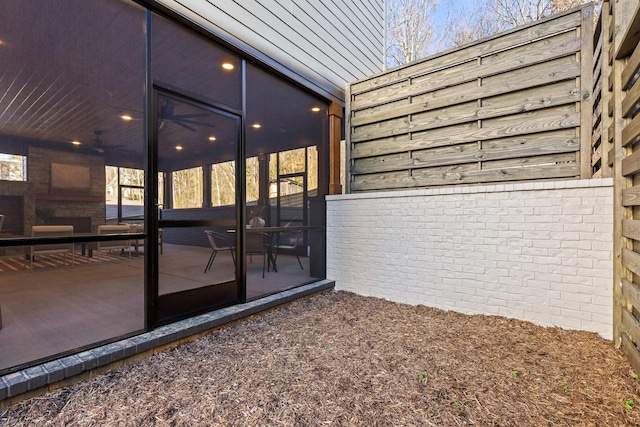 view of property exterior featuring brick siding, a patio area, and a sunroom