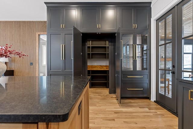 kitchen with dark stone countertops and light wood-style flooring