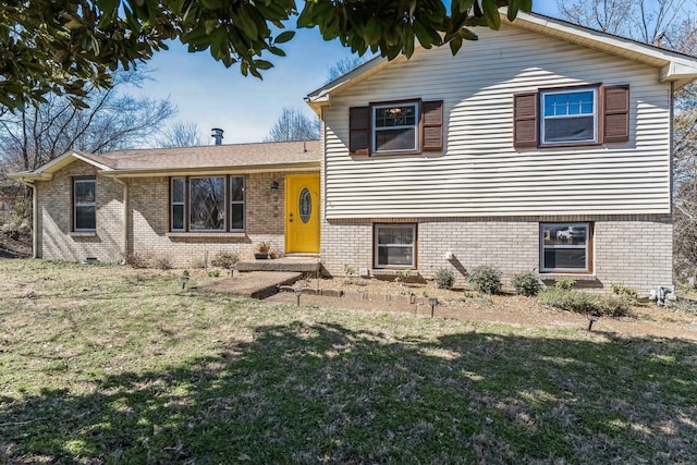 split level home with entry steps, brick siding, and a front lawn