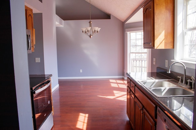 kitchen with dark wood finished floors, dark countertops, decorative light fixtures, stainless steel range with electric cooktop, and a sink