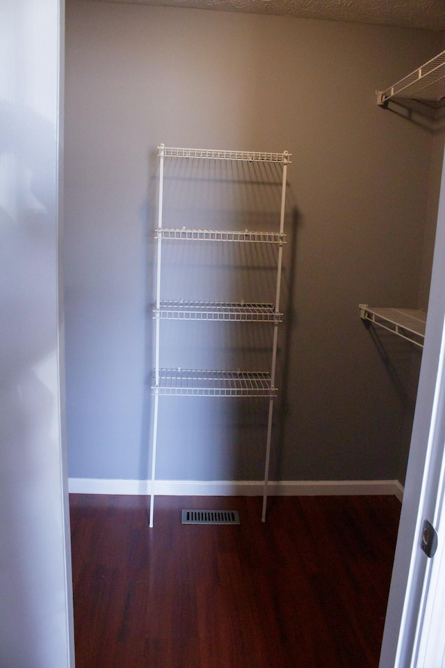 walk in closet with visible vents and wood finished floors