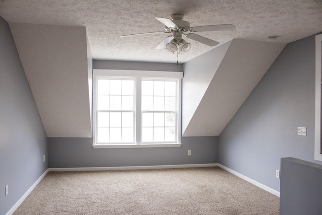 additional living space featuring carpet, baseboards, and a textured ceiling