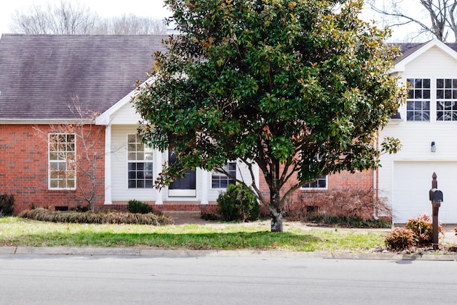 view of front of house featuring brick siding and roof with shingles