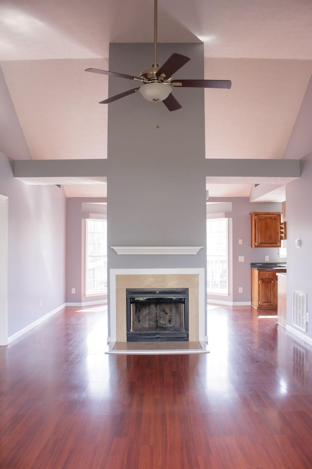 unfurnished living room featuring ceiling fan, a fireplace, wood finished floors, visible vents, and baseboards