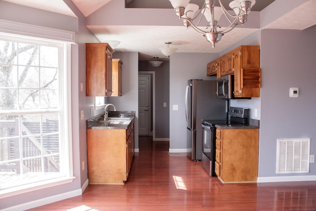 kitchen with dark wood-type flooring, a sink, visible vents, electric stove, and stainless steel microwave