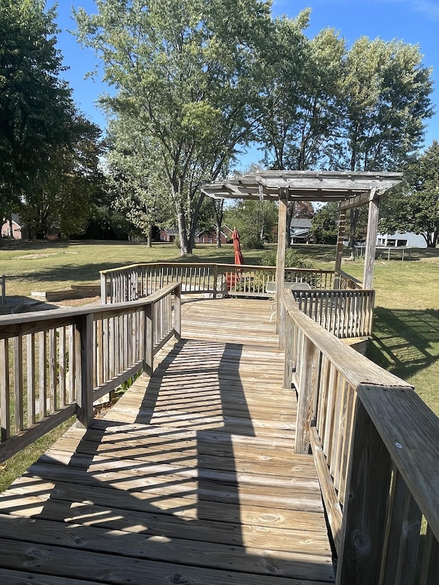 wooden terrace featuring a lawn and a pergola