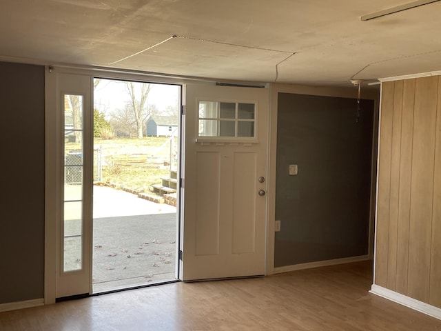 doorway to outside with wood finished floors and baseboards