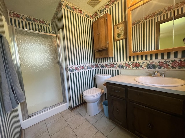 bathroom with visible vents, toilet, a stall shower, a textured ceiling, and wallpapered walls