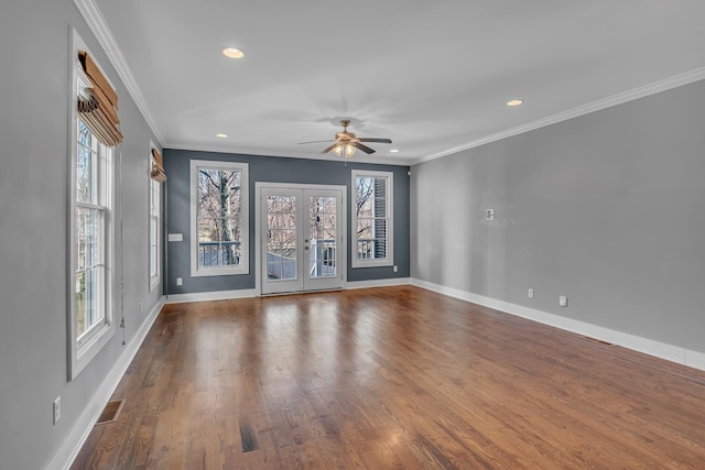 empty room with french doors, plenty of natural light, baseboards, and wood finished floors