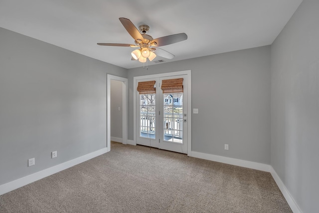 carpeted spare room featuring ceiling fan and baseboards