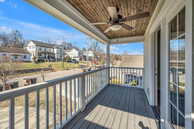 wooden deck with a residential view and a ceiling fan