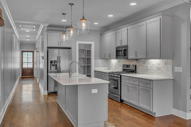 kitchen featuring dark wood-style floors, crown molding, stainless steel appliances, gray cabinetry, and a sink