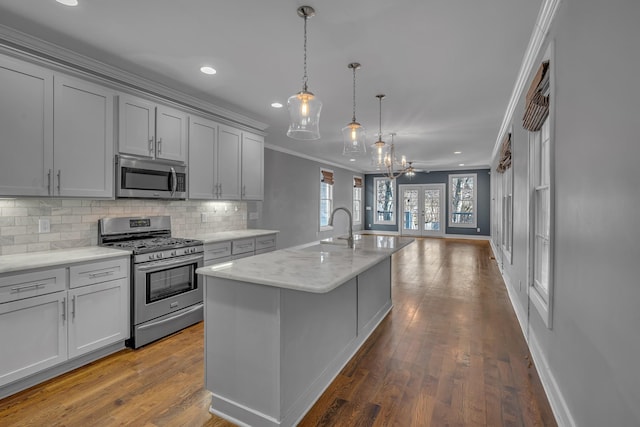 kitchen featuring stainless steel appliances, a sink, ornamental molding, french doors, and tasteful backsplash