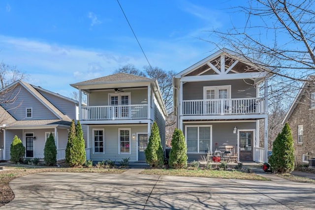 view of front of property featuring ceiling fan, a shingled roof, covered porch, and a balcony