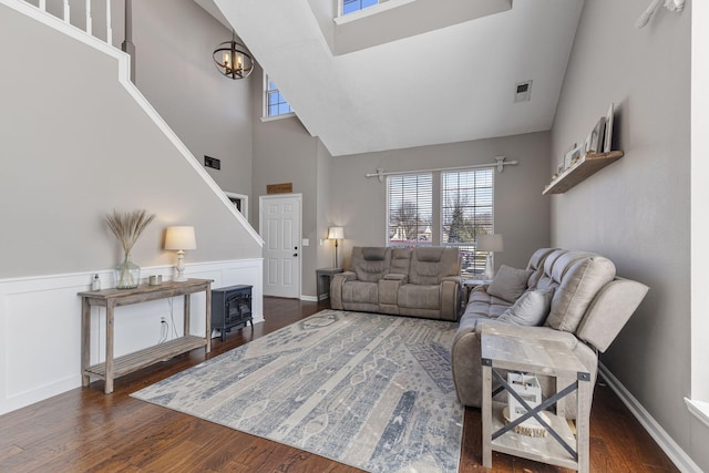 living room featuring an inviting chandelier, wood finished floors, and wainscoting