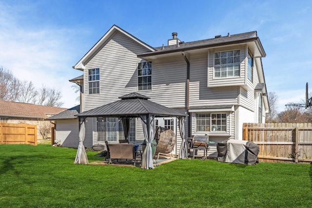 back of house with a gazebo, a yard, fence, and a chimney