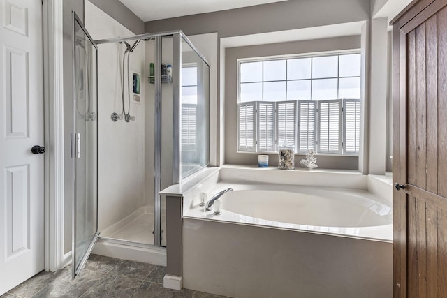 bathroom featuring a bath and a shower stall