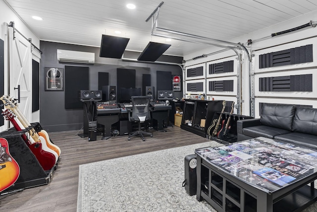 interior space with a wall mounted air conditioner, wood finished floors, recessed lighting, a barn door, and a garage