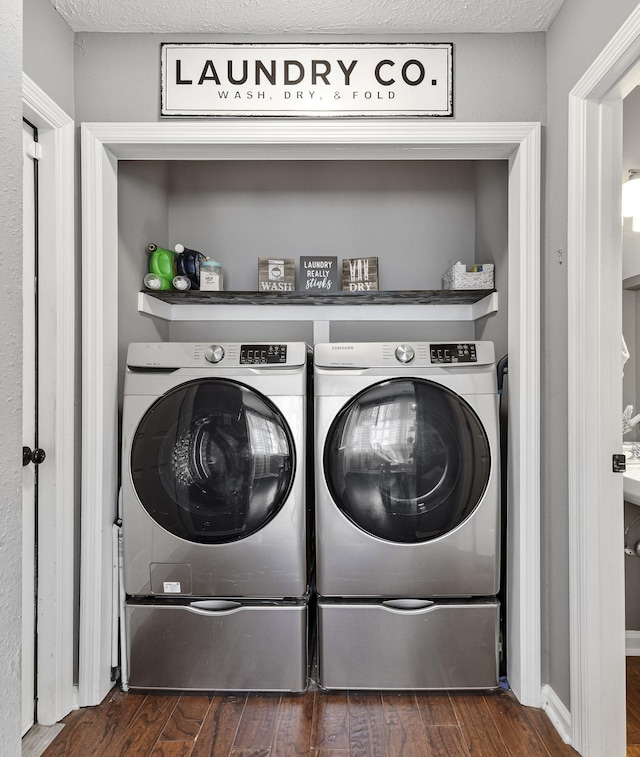 laundry area featuring a textured ceiling, dark wood-style floors, laundry area, and washing machine and clothes dryer