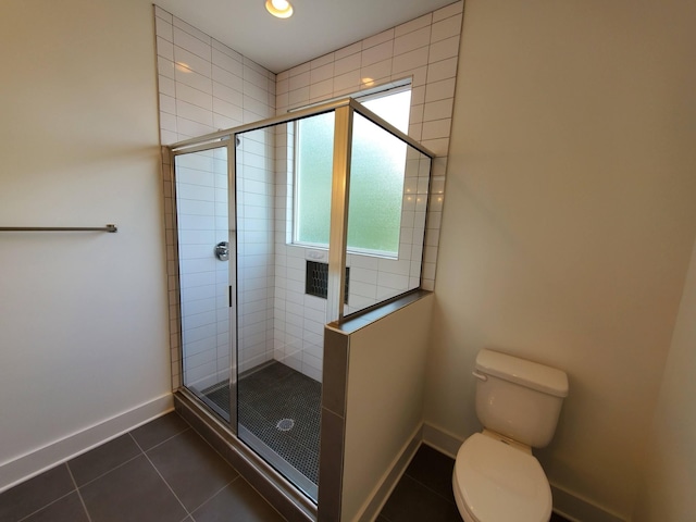 full bathroom featuring tiled shower, tile patterned flooring, toilet, and baseboards