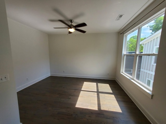 spare room with dark wood-style floors, baseboards, and visible vents