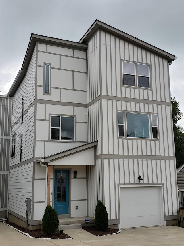 view of front of house with board and batten siding, concrete driveway, and an attached garage