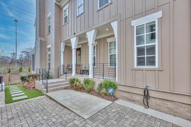 property entrance with a porch, board and batten siding, and fence