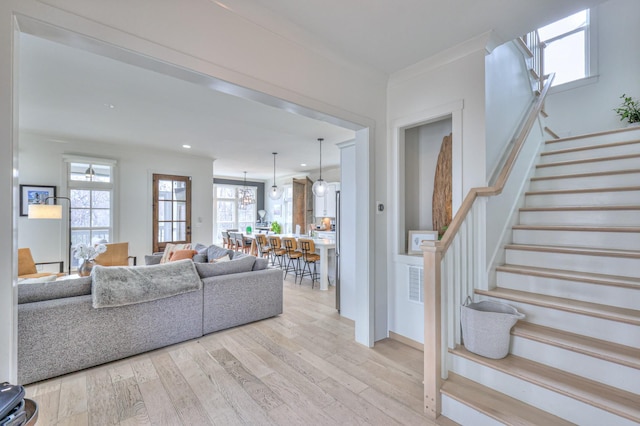 living area with plenty of natural light, stairs, wood finished floors, and recessed lighting