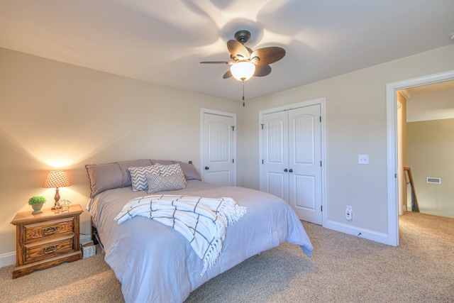 bedroom featuring carpet floors, a closet, visible vents, ceiling fan, and baseboards