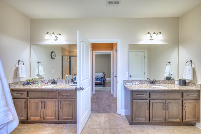 bathroom featuring two vanities, a stall shower, visible vents, and a sink