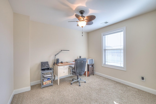 office area with baseboards, a ceiling fan, visible vents, and light colored carpet