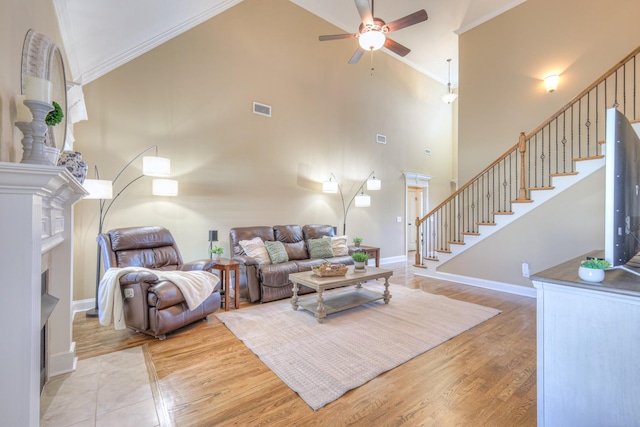 living area with stairway, light wood-style flooring, visible vents, and crown molding