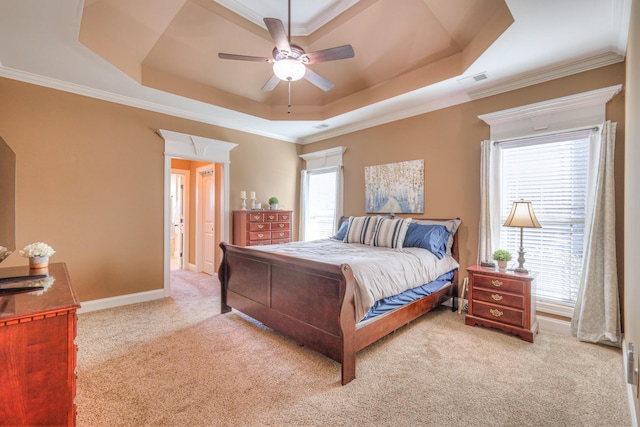 bedroom featuring carpet floors, attic access, multiple windows, and a tray ceiling