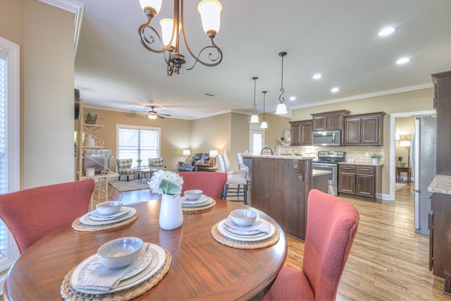 dining room featuring light wood-style floors, recessed lighting, ornamental molding, and ceiling fan with notable chandelier