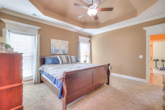 bedroom featuring a tray ceiling, carpet flooring, visible vents, and baseboards