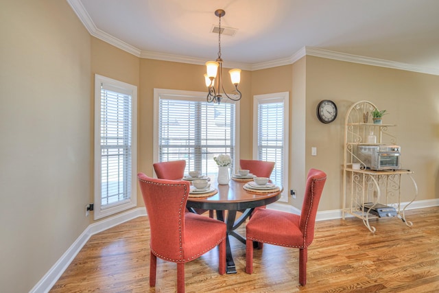 dining room featuring a notable chandelier, crown molding, baseboards, and wood finished floors