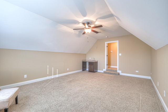 bonus room with lofted ceiling, light colored carpet, ceiling fan, and baseboards