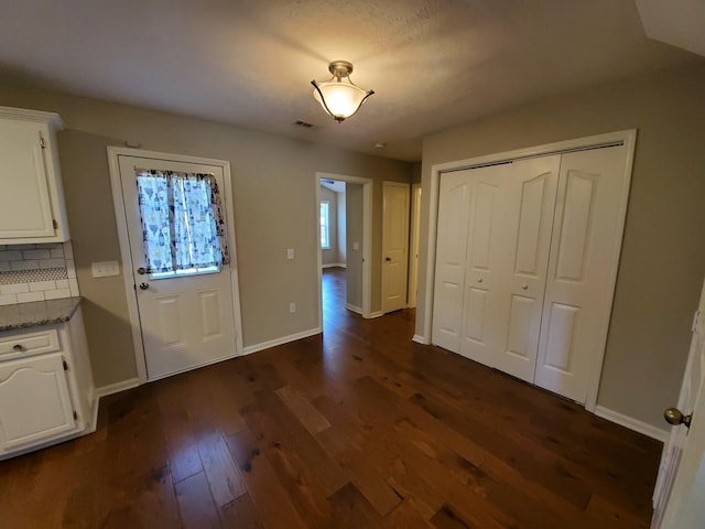 entryway featuring visible vents, dark wood finished floors, and baseboards