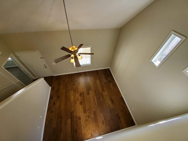 unfurnished living room with lofted ceiling, ceiling fan, baseboards, and wood finished floors