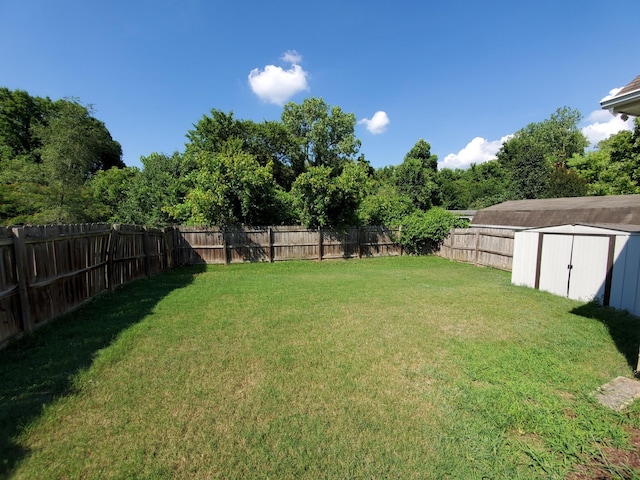 view of yard featuring a storage shed, an outdoor structure, and a fenced backyard