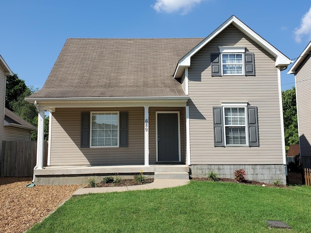 view of front of home with covered porch, a front lawn, roof with shingles, and fence