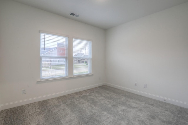 carpeted spare room with baseboards and visible vents