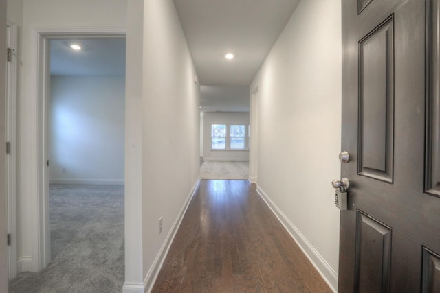 corridor with baseboards, dark carpet, dark wood finished floors, and recessed lighting